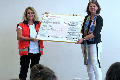 Evelin Plötz, Beiratsmitglied Tierrettung München, nahm von Margit Dürnberger, Leiterin der Kindertagesstätte, die Spende entgegen.